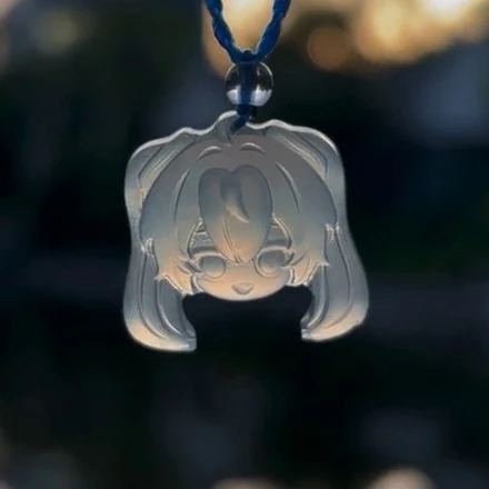 Backlit view of Hatsune Miku pendant D37B, with light shining through the carved face and hair