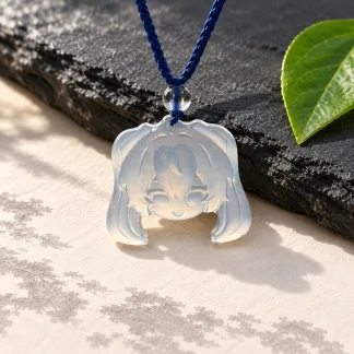 AI-assisted presentation of the Hatsune Miku Portrait Edition D37B pendant on a navy braided cord, with slate, warm paper and a green leaf